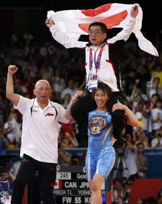 3連覇を達成した吉田沙保里が、父の栄勝コーチを肩に乗せリングを歩く＝9日、エクセル （ロイター）