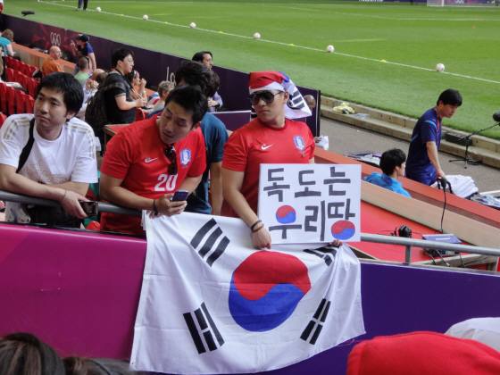 上の韓国コーチングスタッフの一番下の左の男が朴鍾佑（パク・ジョンウ）に「独島はわれわれの領土」と書いた紙を渡した男だと言われている。